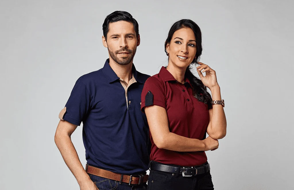 Dos colaboradores con camisas tipo polo en azul marino y vino, con vivos de contraste.