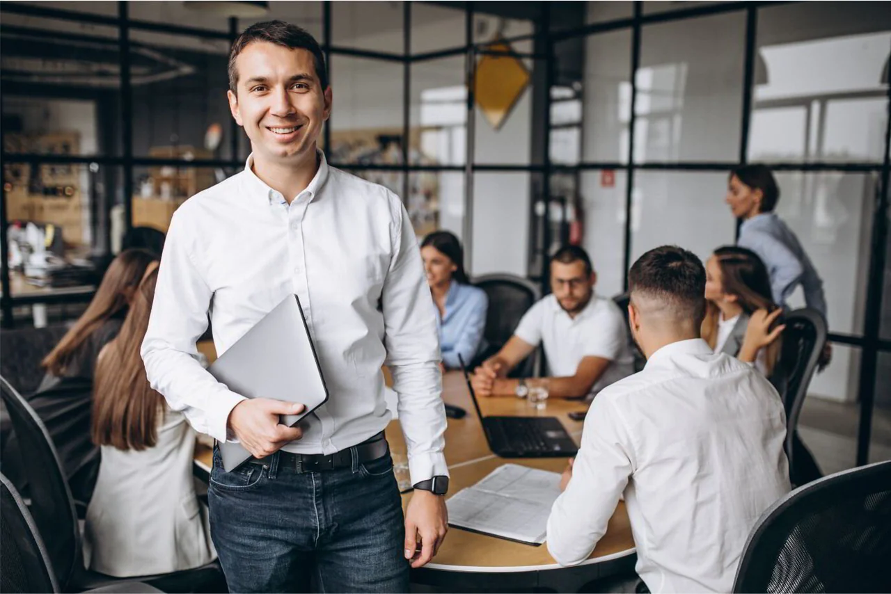 Equipo de oficina reunido alrededor de una mesa de trabajo.