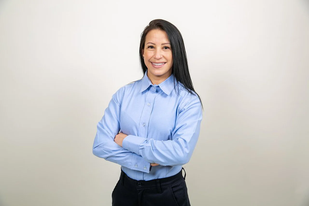 Colaboradora con camisa de oficina celeste de manga larga.