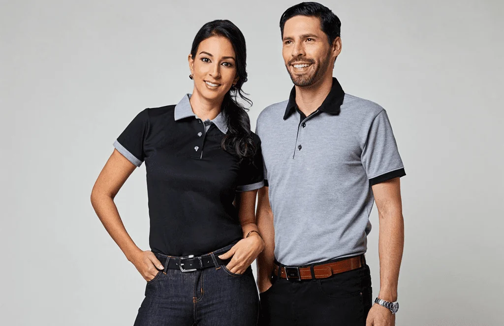 Dos colaboradores con camisas tipo polo negras y grises con vivos de contraste.